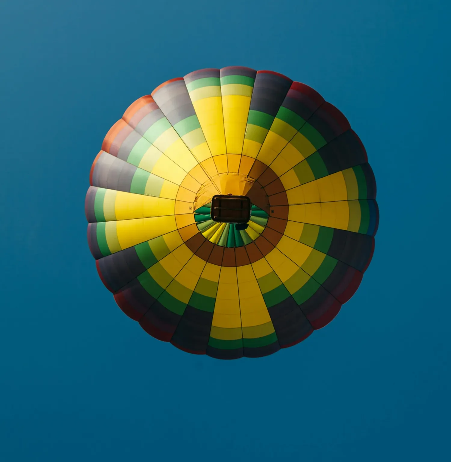 ground view of balloon flying up against blue sky